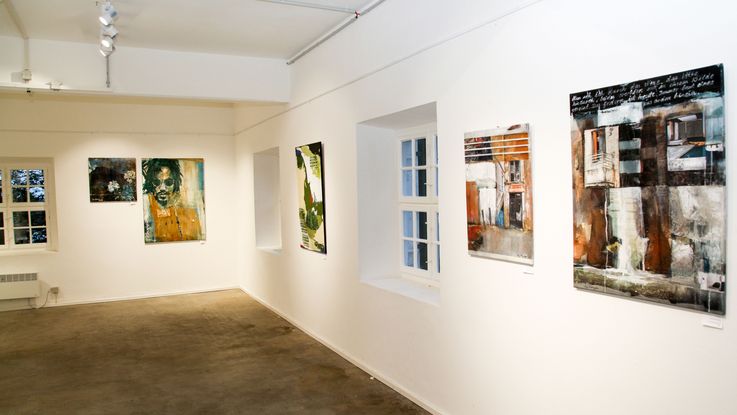 Innenbereich einer Kunstausstellung mit Kunstwerken an den Wänden