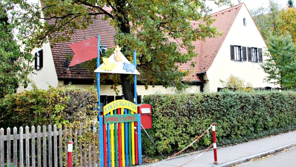 Bunte Tortür des Einganstores des Kindergartens mit Blick auf das Kindergartenhaus