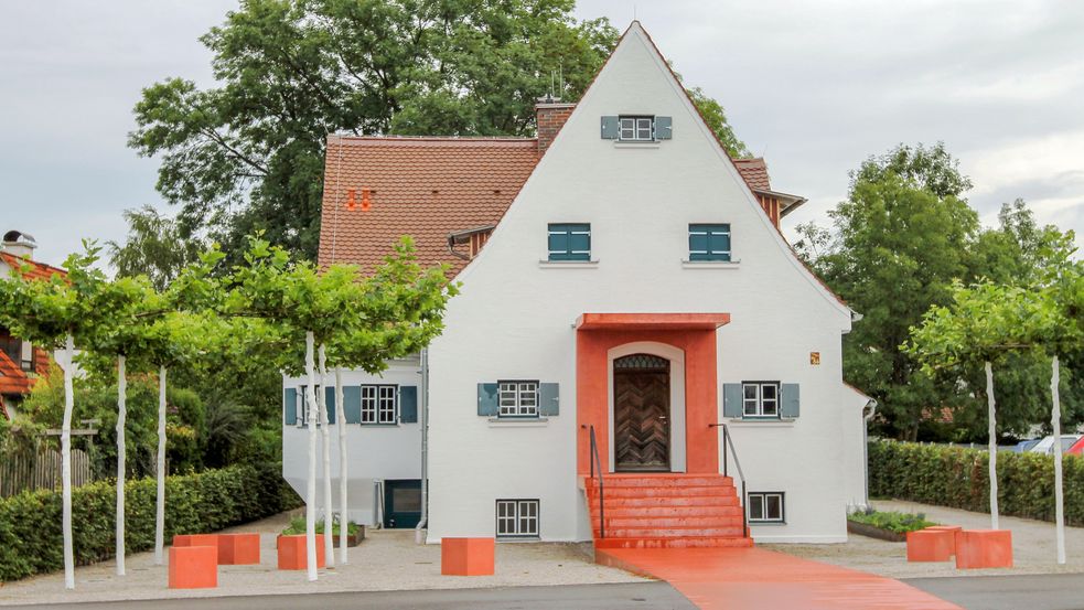 Haus bei dem der Eingangsbereich leuchtend orange gestaltet ist