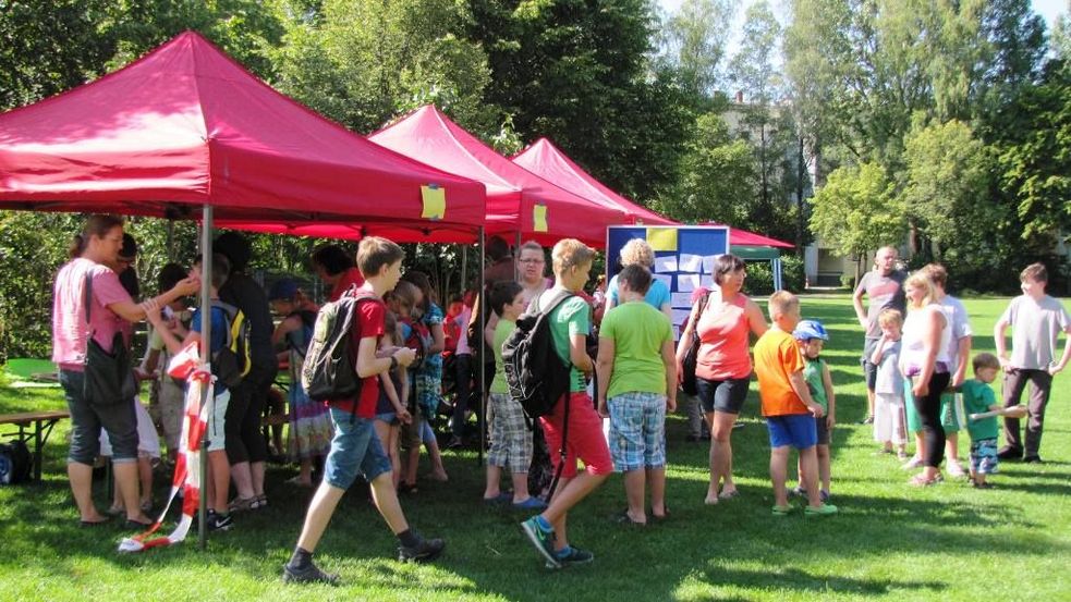 Eltern und Kinder gehen von Stand zu Stand bei der Veranstaltung Spielstadt Dachau