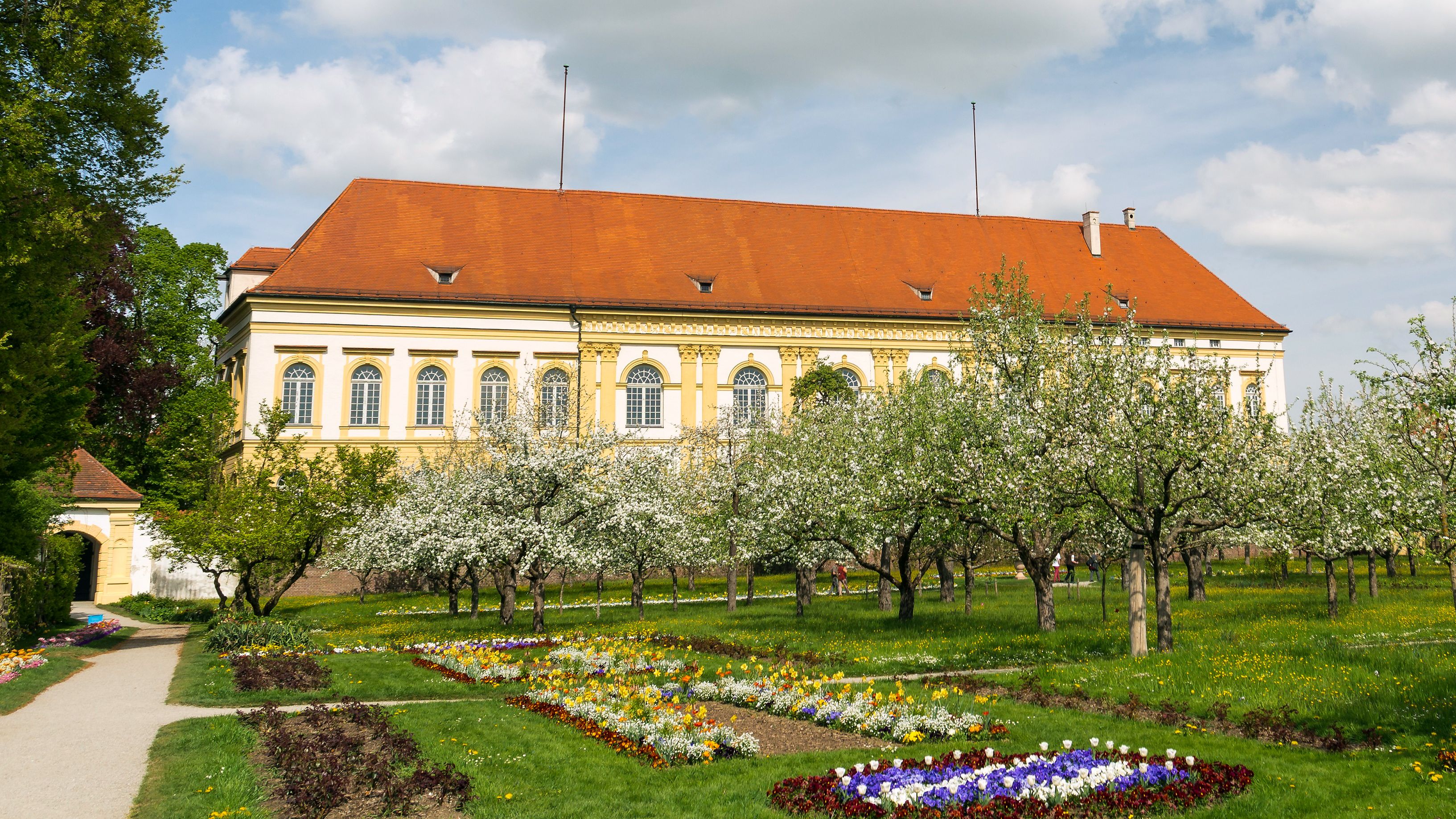 Schlossgarten in voller Blüte, im Hintergrund das Schloss