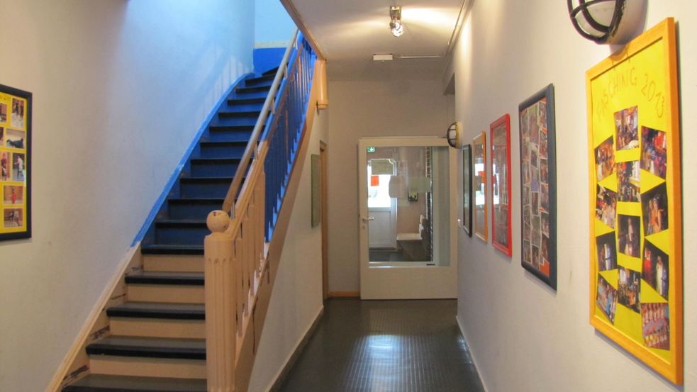 Flur mit Treppe und vielen Foto-Collagen an der Wand