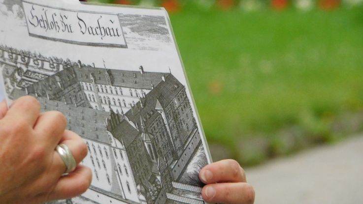 Photo section of the city tour, tour guide shows historical view of the Dachau castle