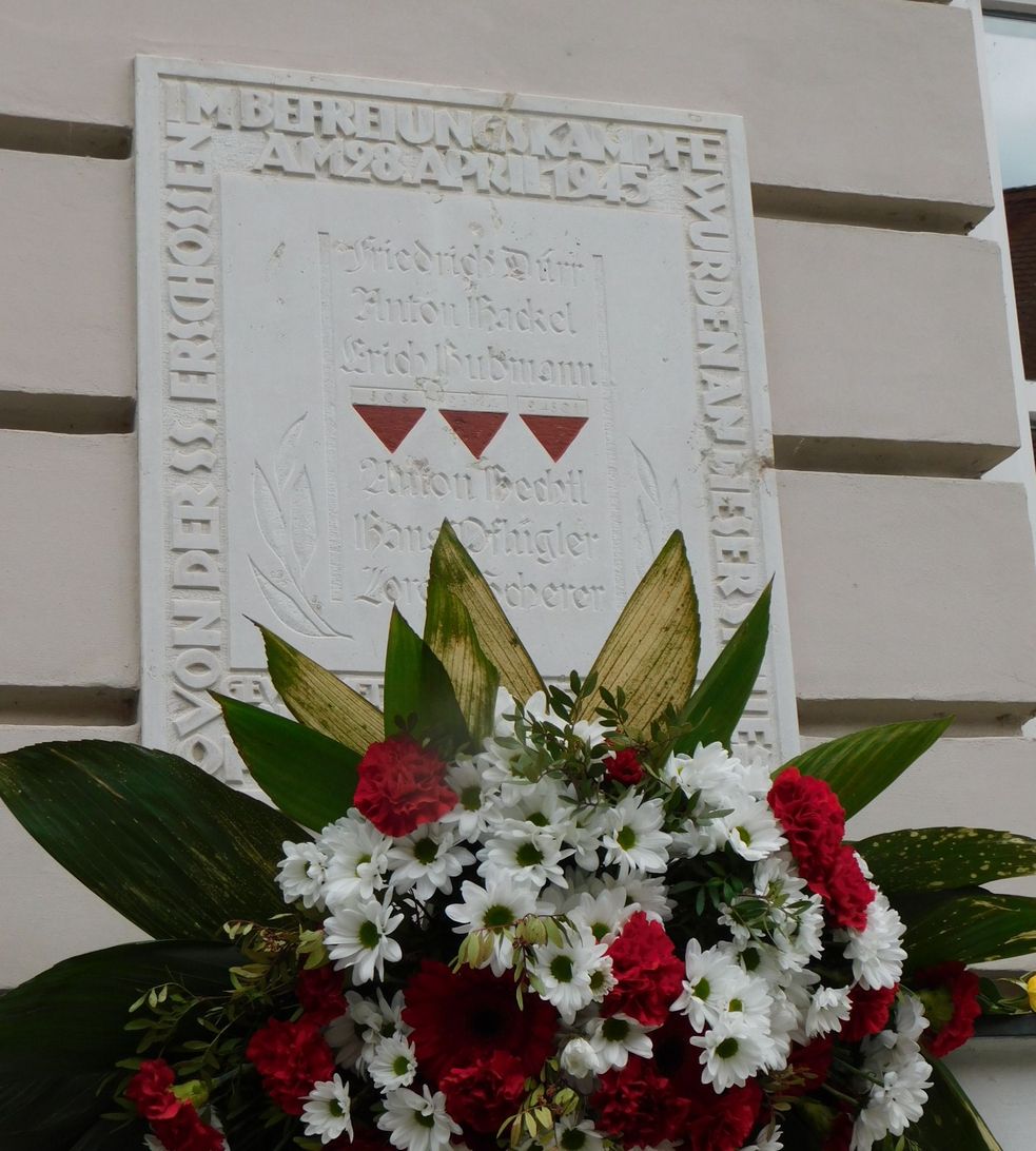 Gedenktafel zum Dachauer Aufstand mit Blumenschmuck