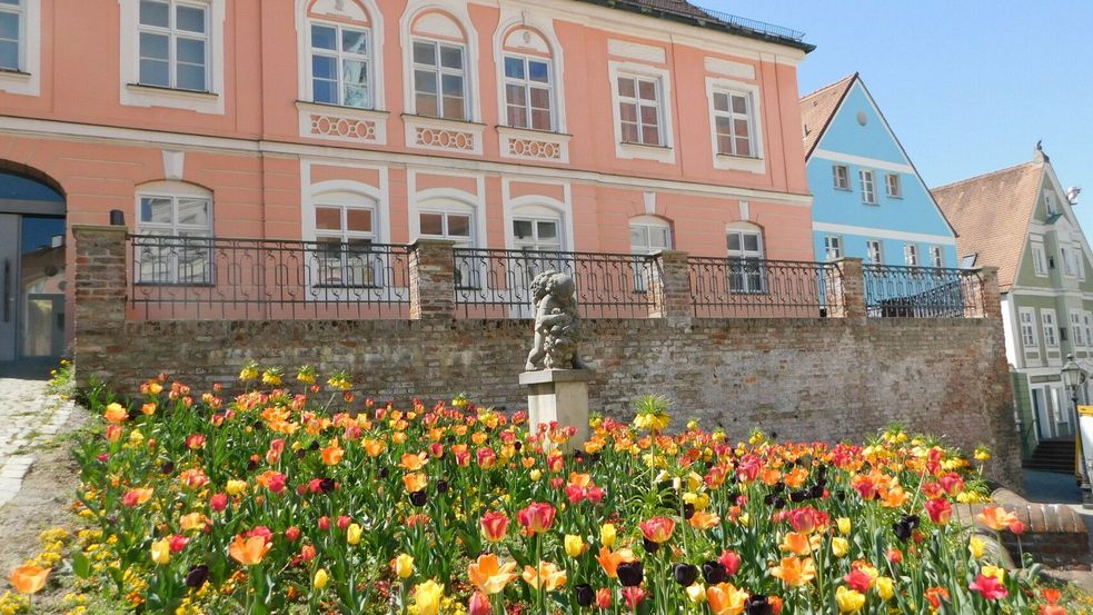 Gebäudefassade des Bezirksmuseums Dachau mit Blumen im Vordergrund